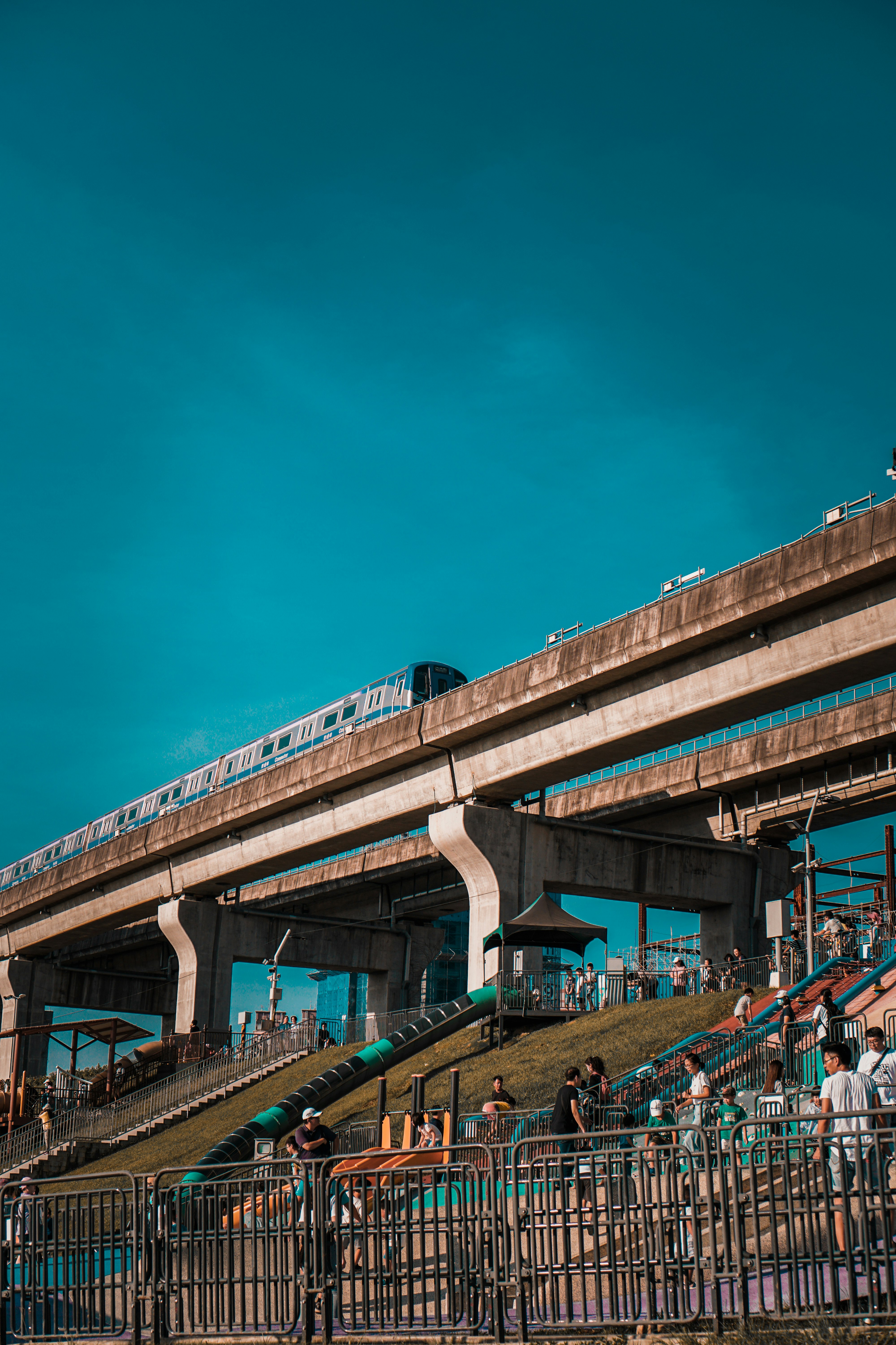 people walking on bridge under blue sky during daytime